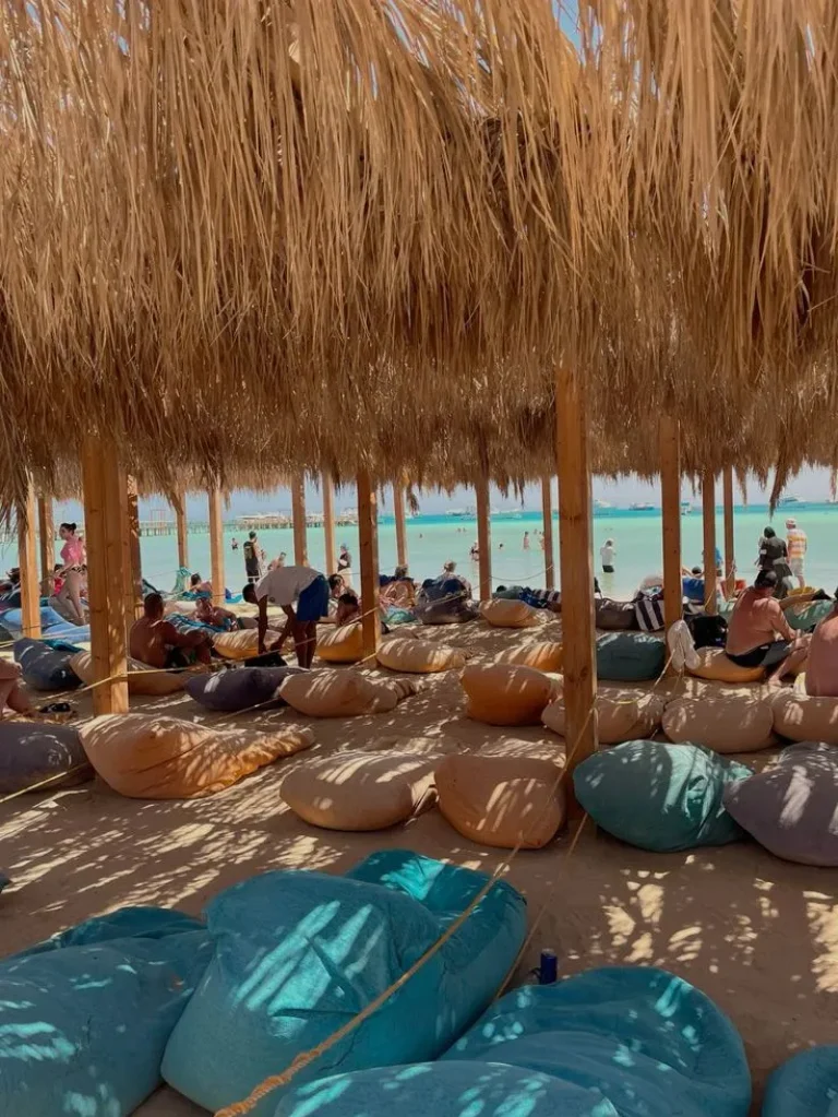A solo traveler walking along a pristine beach in Hurghada, enjoying the clear waters and sunny skies